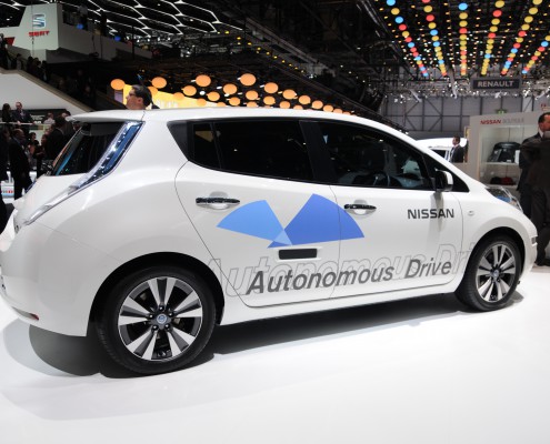 A white car, with automatic drive printed on it. Driverless car.