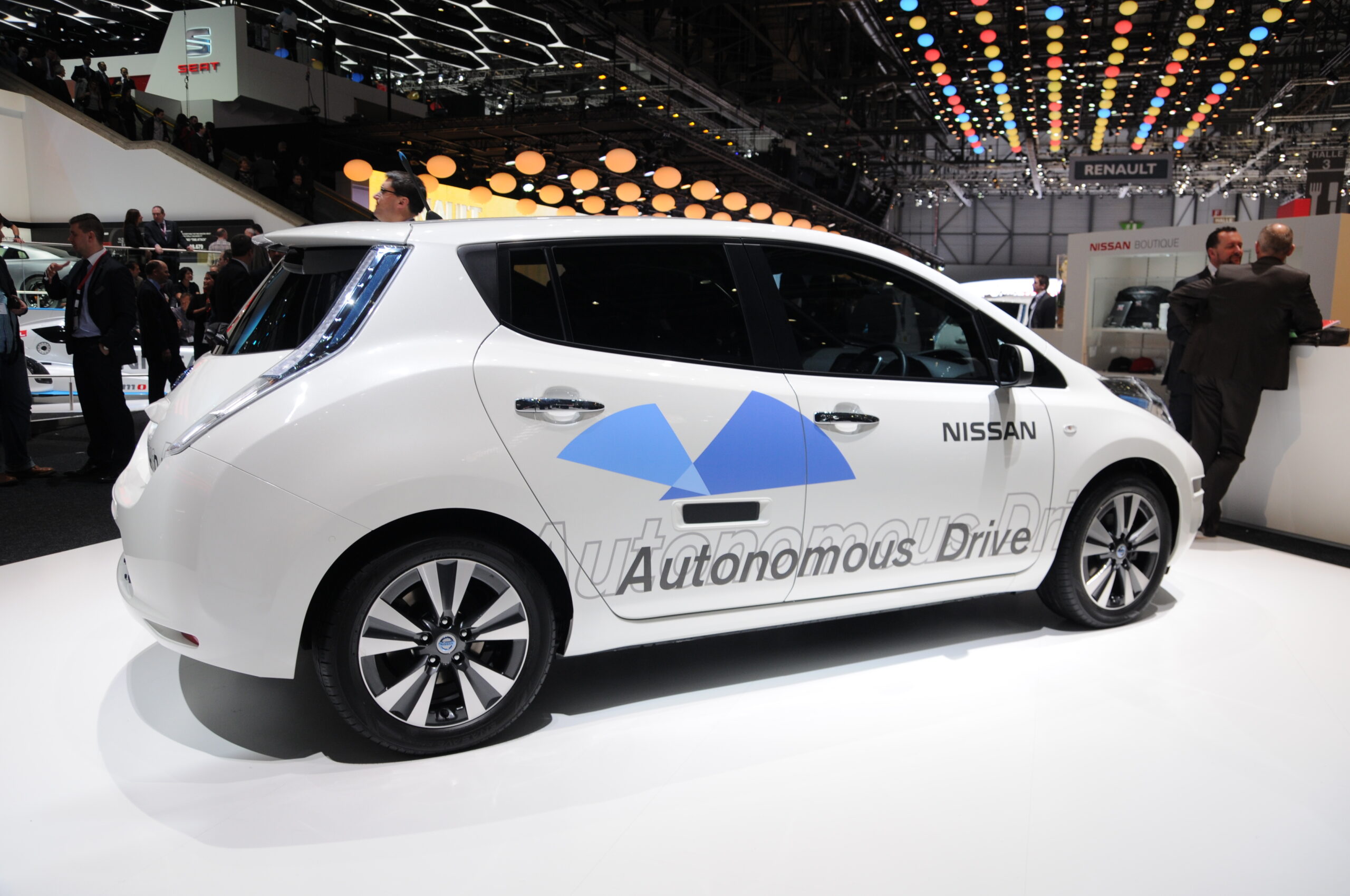 A white car, with automatic drive printed on it. Driverless car.