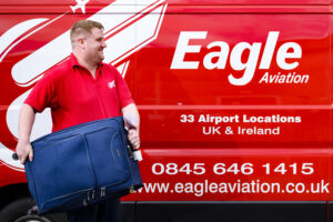 Eagle Aviation courier carries suitcase into van